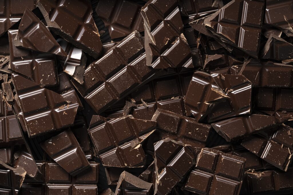 A pile of chocolate pieces on a black background.